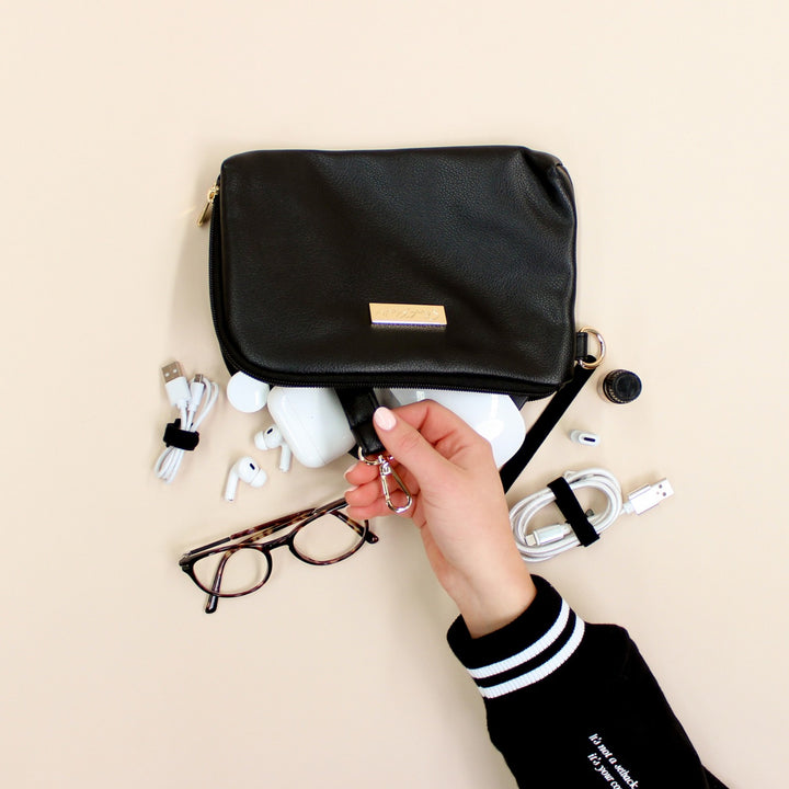 Black faux leather cable organiser bag with zip, removable strap, tech loops and multiple storage pockets.