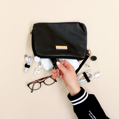 Black faux leather cable organiser bag with zip, removable strap, tech loops and multiple storage pockets.