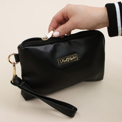 Black faux leather cable organiser bag with zip, removable strap, tech loops and multiple storage pockets.